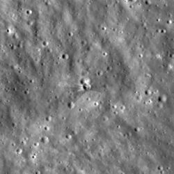 Gråskalig vy av månens yta ovanifrån, med ett kraterlandskap och en liten, ljus nedslagsplats i mitten omgiven av ljusa stråk av utkastat material. Jämförelse av två bilder från NASA Lunar Reconnaissance Orbiter (LRO) som visar området på månen före (vänster) och efter (höger) nedslaget av den övre delen av en SpaceX Falcon 9-raket. Den nya kratern, cirka 18,3 meter bred, syns mitt i bilden och ligger ovanpå en äldre krater av nästan samma storlek. Efter nedslaget den 5 augusti fotograferade LRO området under sin förbiflygning den 11–12 augusti. Fördröjningen berodde på satellitens omloppsbana runt månen.