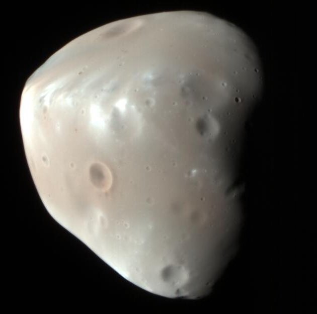 Närbild av Phobos, Mars oregelbundna grå måne, med många nedslagskratrar och ljusa partier mot en djupt svart bakgrund av rymden.