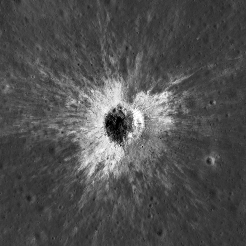 McGetchin crater from LRO_NASA-GSFC-Intuitive Machines En flygbild av en månkrater med ett mörkt, cirkelformat centrum omgivet av ett ljust, strålande mönster av utkastat material mot månens grå yta.